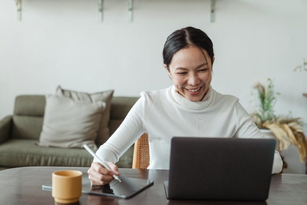 Woman working at home and making video call on laptop. She is a freelance bookkeeper for ResultsResourcing.