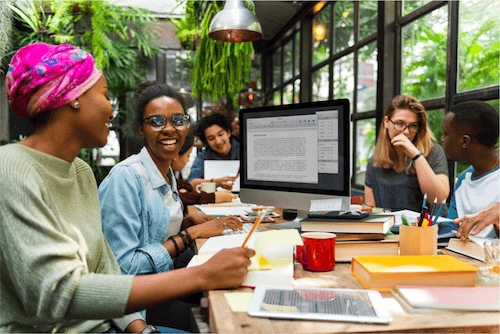 Freelance millennials working together in a shared workspace suggesting the efficiency of virtual talent and the ​benefit of recruiting a younger generation of virtual workers for a small business.