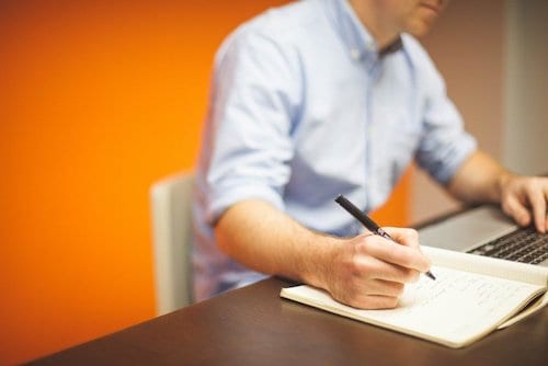 Man writing out his business plan for post-COVID​ and narrowing down the things his business should be doing right now to set himself up for success. 