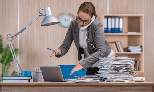 A busy financial advisor answering a phone while multitasking suggests that she needs freelance help to scale her business.