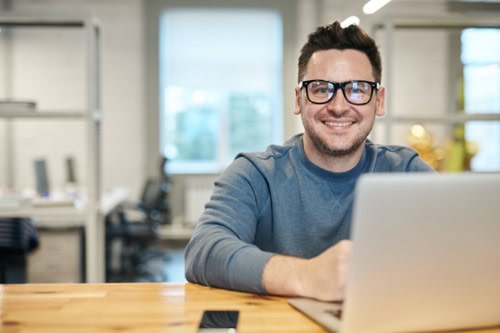 Freelance marketing professional sitting at a computer executing digital marketing campaigns.