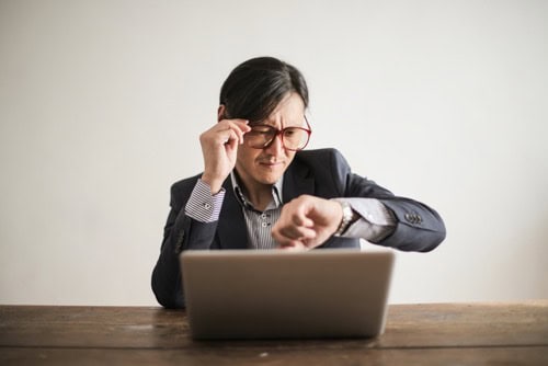 A business owner looking at his watch and looking busy indicating he doesn't know the value of his time.