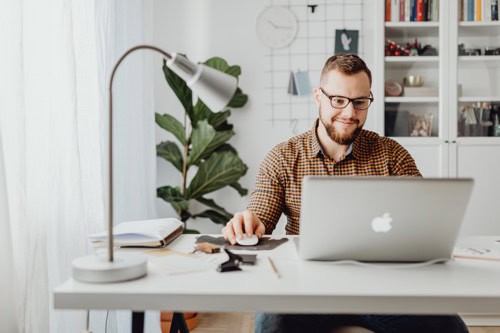 A photo of a small business owner who is ready to hire a solopreneur doing research on his computer.