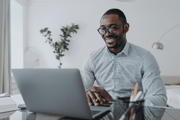 A business development freelance consultant is looking at a laptop in a home office.