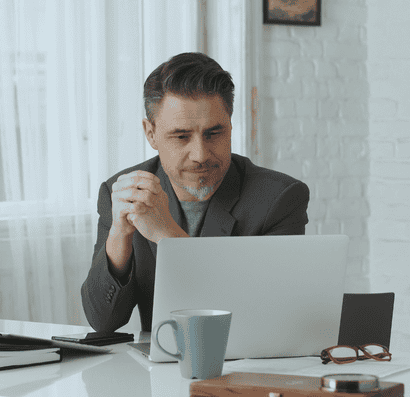 A man working as an HR virtual assistant looks at his laptop screen.
