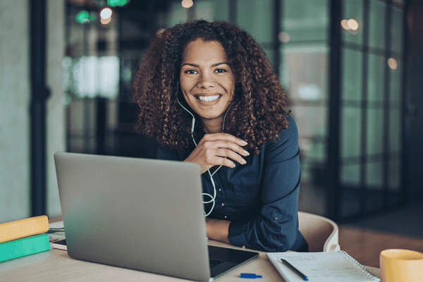 An online business manager sits in front a computer with headphones on.