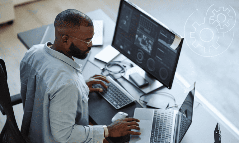 A male entrepreneur with small business automation in place sitting at his computer reading a report.