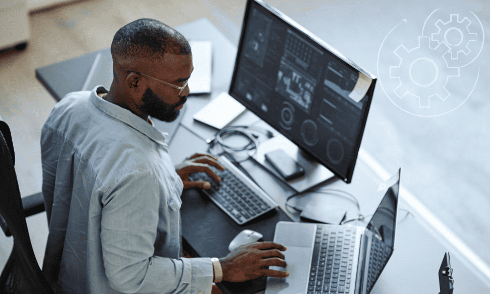 A male entrepreneur with small business automation in place sitting at his computer reading a report.